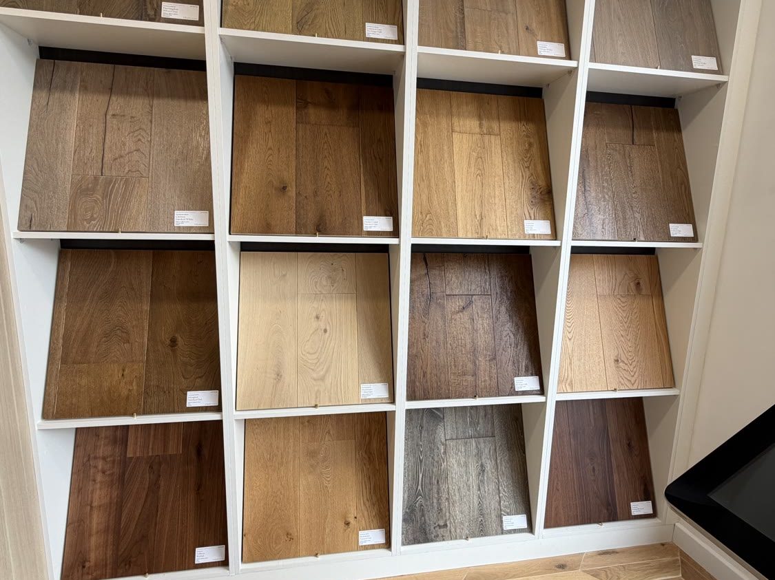 Grid of wide-plank wood flooring samples displayed on the cube shelving wall at Hampton Hill Flooring